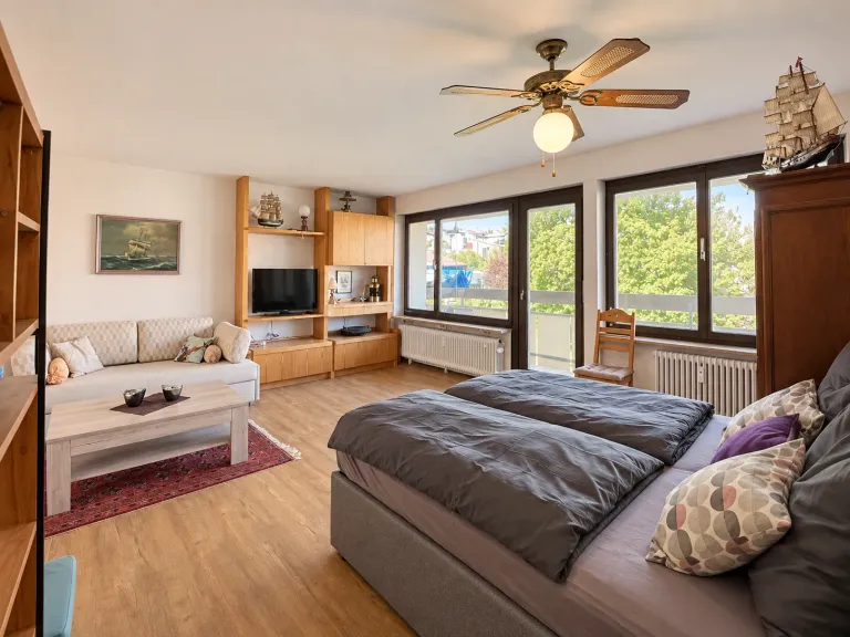 Bett und Sofa vor der Fensterfront in der Seglerstube in Bodman – Seglerstube Bodman in Bodman