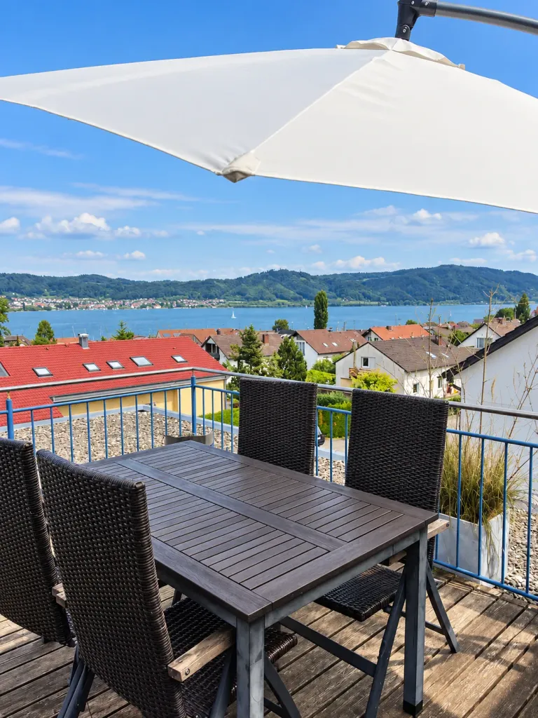 Sitzgruppe auf dem Balkon mit Blick auf die Dächer und den See – AVIVA Sonnendeck in Bodman