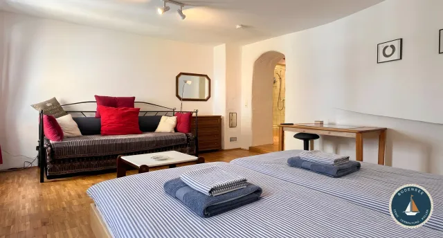 Doppelbett und rotes Sofa im Zum Hinteren Kranich in Konstanz